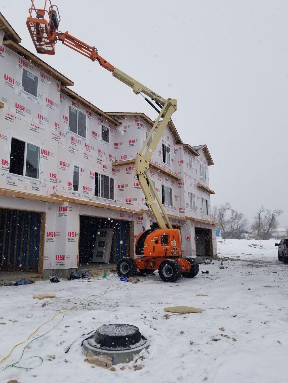 Multi-unit building wrapped and prepped for siding in winter