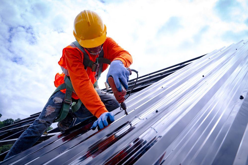 Roofer installing metal roofing panels